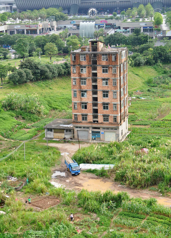 前不久（6月8日），龙华新区地理位置远不如此的一宗商住混合用地，成交价被拍出140.6亿元，晋升今年全国土地总价新地王。这栋犹如孤岛的七层小楼，重新回到公众的视野。